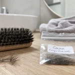Cheveux qui casse : mèches cassées et brosse près de la salle de bain